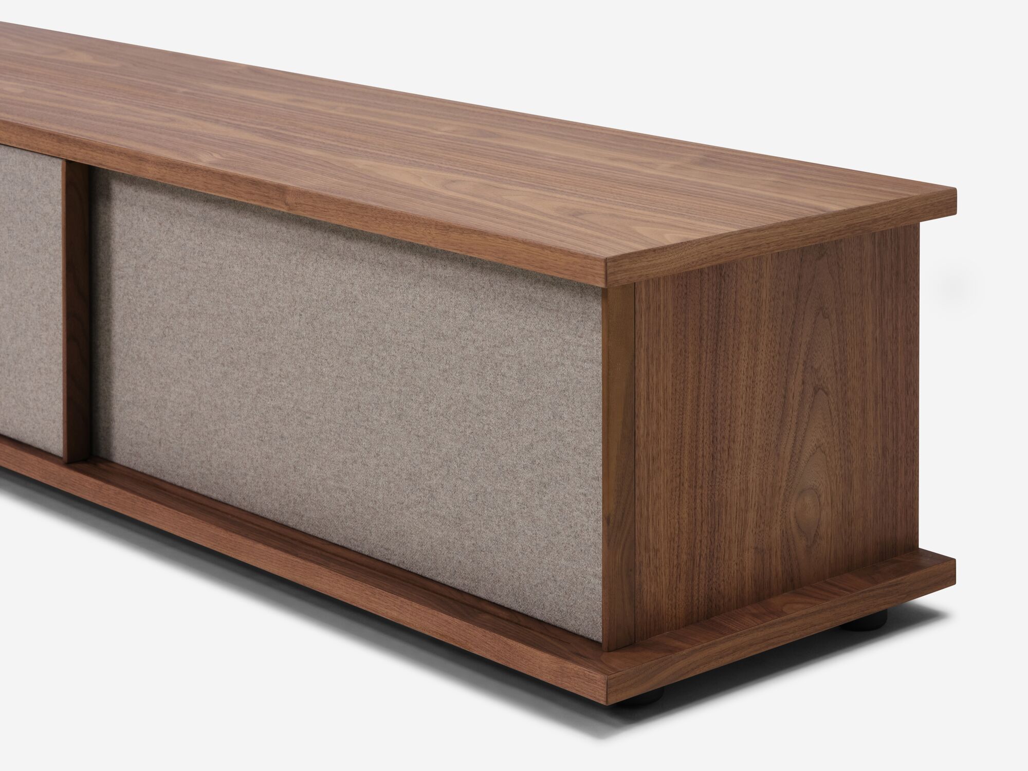 Angled view of the Plank mid century media console in walnut with fabric panels